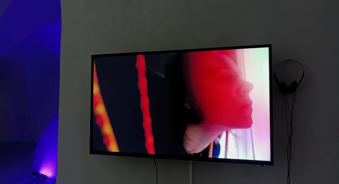 Weibliche Person auf Videoschirm in einer Gewölbegalerie