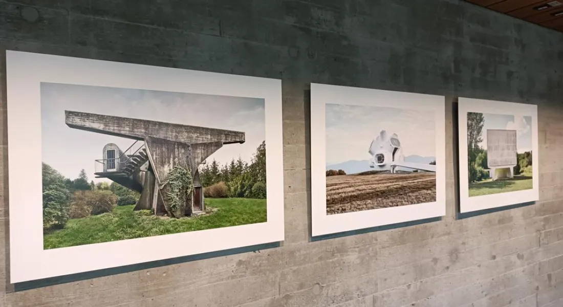Drei Fotoprints von Bauwerken an einer rohen Betonwand