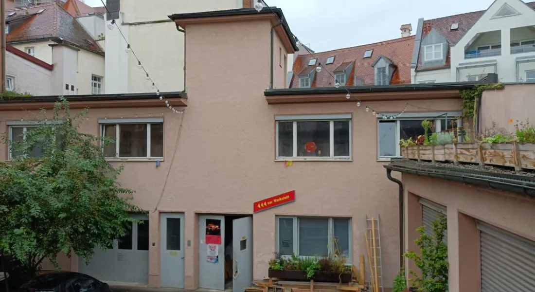 Verwinkelter Hinterhof in der Stadt mit Begrünung an einem Regentag