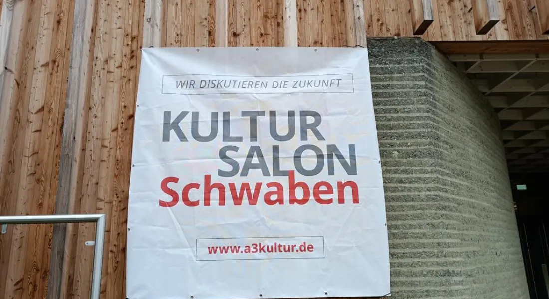 Kultursalon Banner vor Holzwand