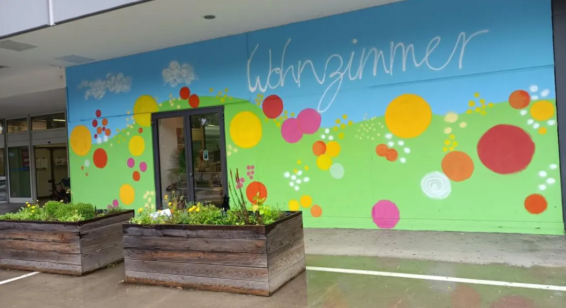 Bunte Außenfassade mit dem Schriftzug »Wohnzimmer«