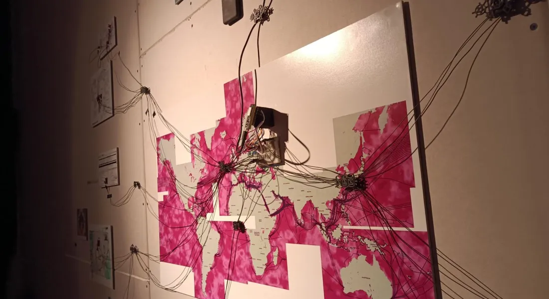 Weltkarte an einer Wand, mit davon ausgehenden Kabelnetzen