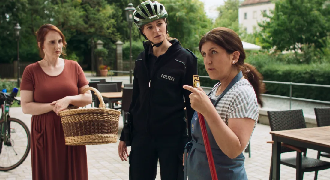 Verkäuferin Lieselotte (Lisa Grötsch, rechts) erklärt der Dorfpolizistin Nadine (Barbara Weiß, Mitte) und Magdalena (Christina Baumer, links) was in den vergangenen Monaten alles in Hundsling geschehen ist. ©Stonewood Film e.V.
