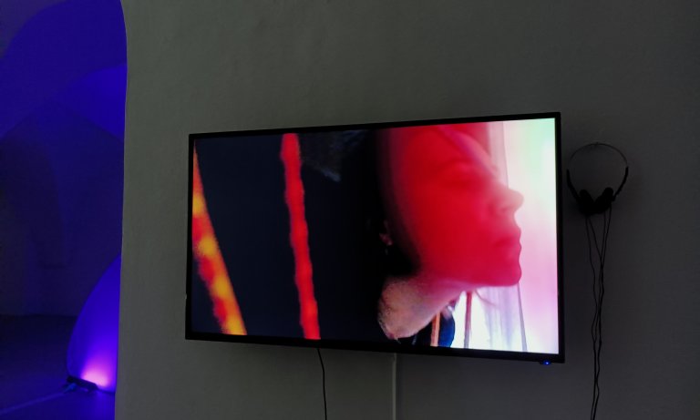 Weibliche Person auf Videoschirm in einer Gewölbegalerie