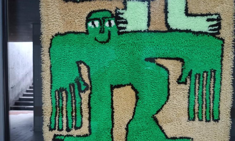 Materialbild (Frottee) in einem Schaukasten mit Treppenaufgang im Hintergrund